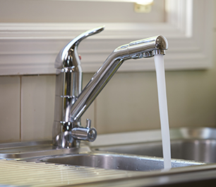 Water flowing out of a kitchen mixer tap into a sink