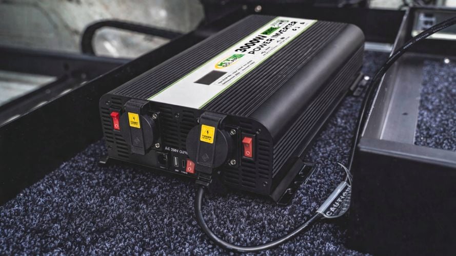 KT Solar 3000W Pure Sine Wave Inverter installed inside a vehicle storage compartment with AC outlets visible.