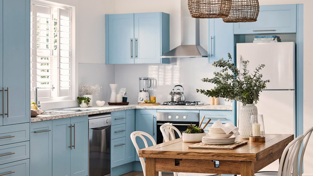 Kitchen with blue cabinetry and marble benchtops.