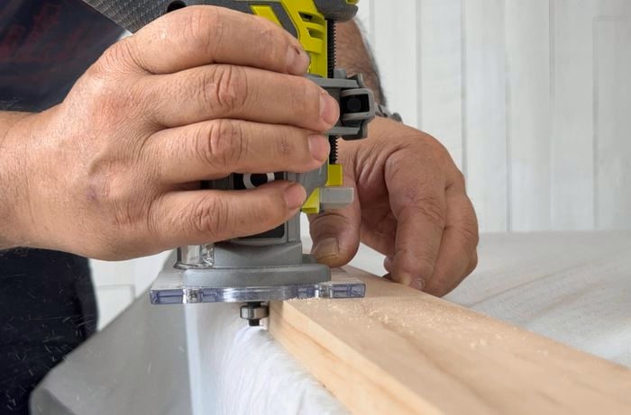 Pine drawer pieces being rebated for drawer base using a trim router.
