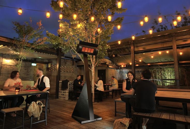 Open air restaurant with tree, fairy lights and freestanding heat lamp