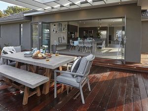 A completed backyard deck attached to a grey painted house