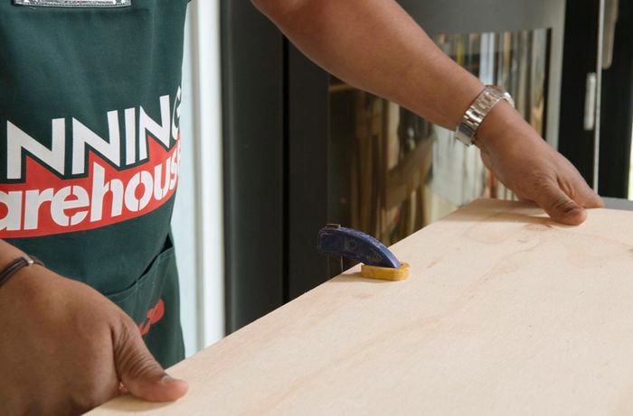 Person clamping timber to workbench