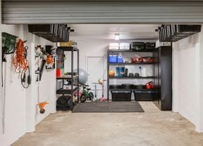 Completed garage makeover with organised shelves, ceiling storage tubs and wall-mounted tools.