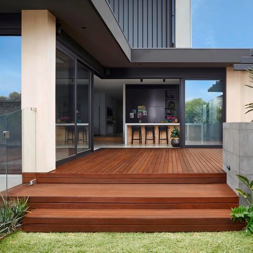 Stairs and decking with wide doors leading to modern indoor kitchen area