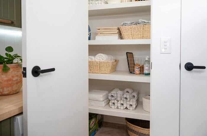 An open storage cupboard in a laundry room.