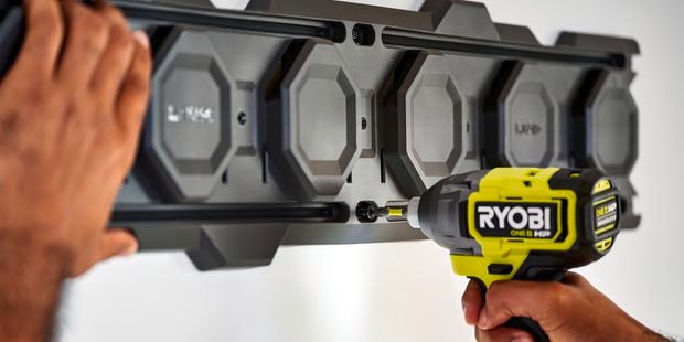 Impact driver fixing screw into LINK wall rail.