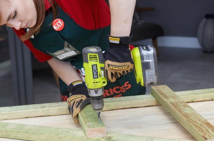 Bunnings team member Jess joining lengths of timber with a cordless drill