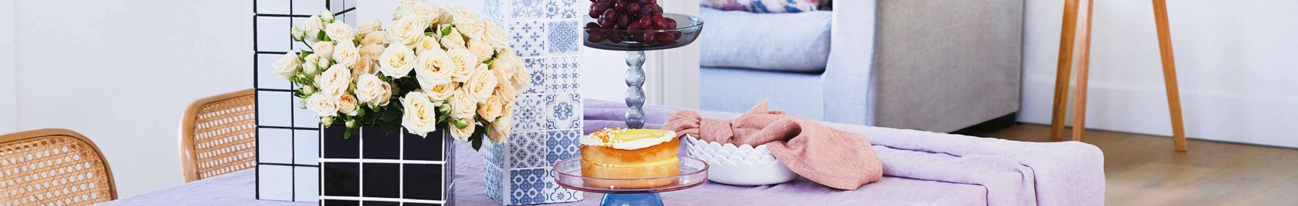 A decorated living room table with cake and flowers.