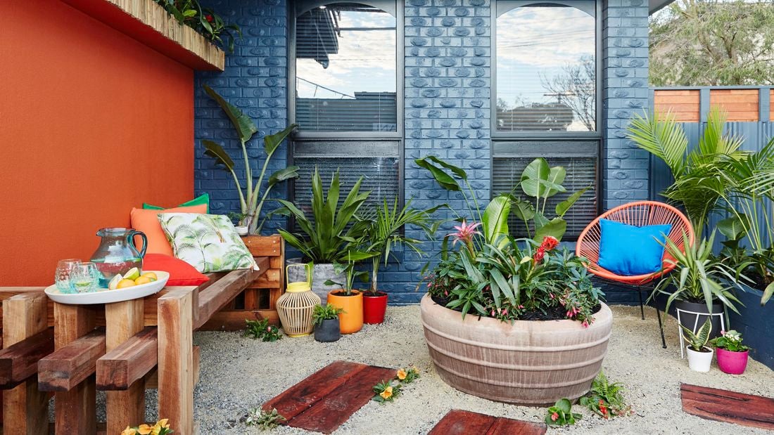 Outdoor area with blue walls and furniture, plants.