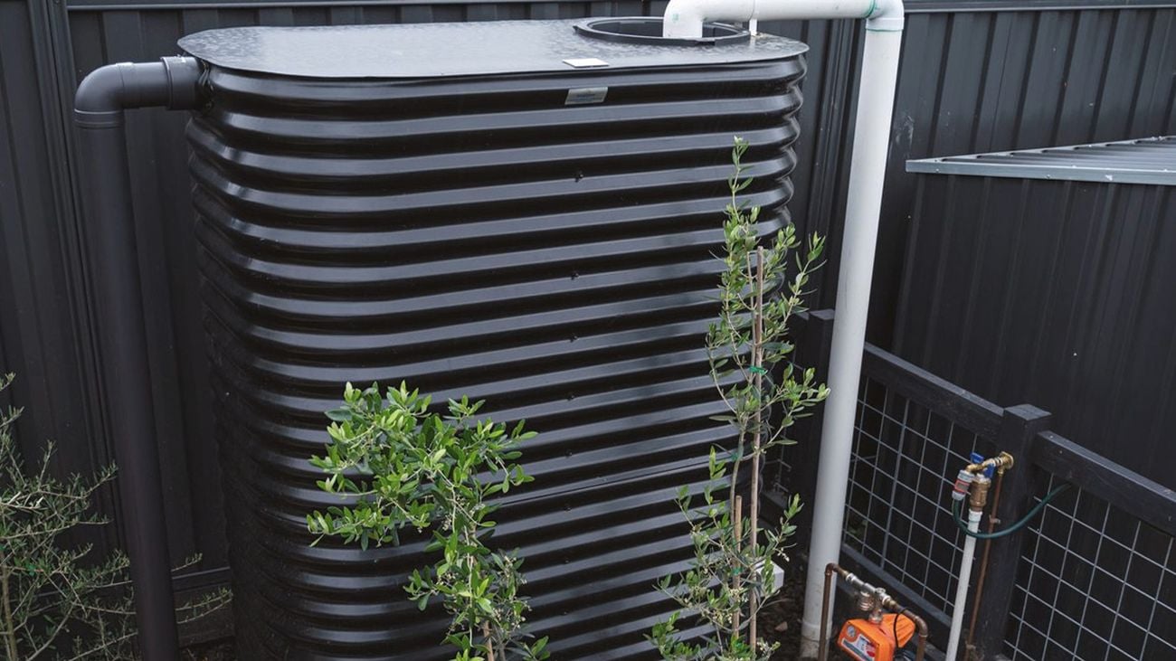 Water tank in the backyard near wooden fence