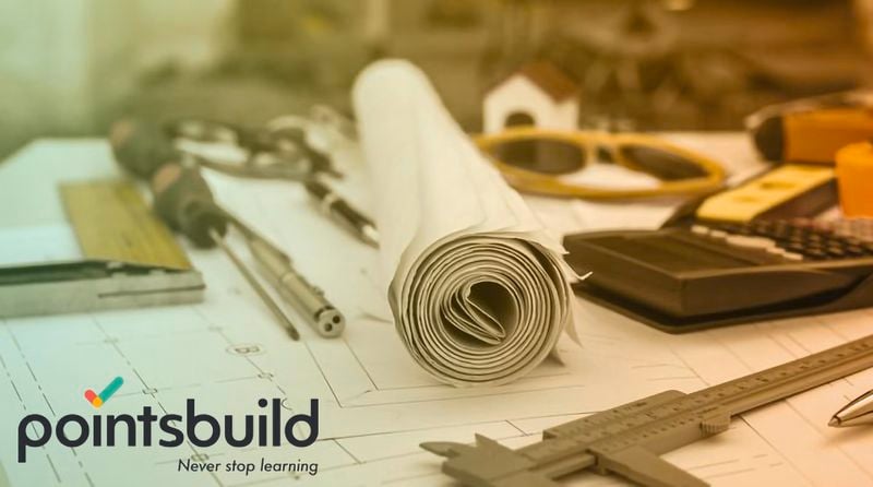 Paper floorplans for a building with calculator, glasses and silver pen.
