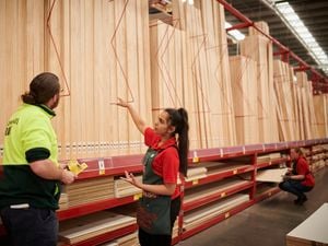 Three Bunnings team members working in a timber yard