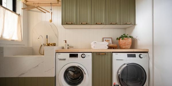 A modern laundry room featuring a front-loading washing machine and a matching dryer placed side-by-side.