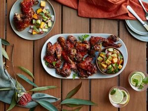 A plate full of sticky chicken wings, served with chilli mango salad