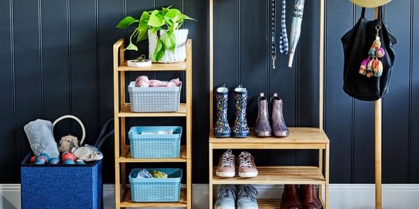 Organised timber shelving rack, with kids boots and shoes and hanging bag and umbrella off hooks. Separate hat stand with hats and small four tier rack with basket organisers.