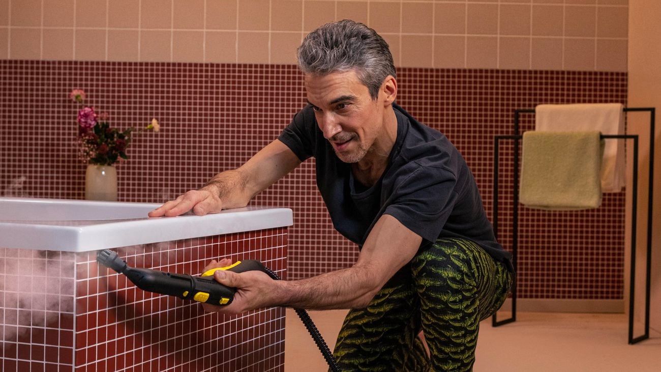 Person using steam cleaner to clean bathtub.