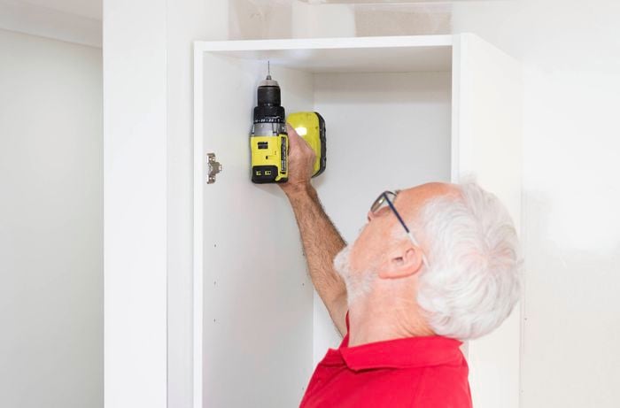 Pre drill the holes in the cabinet using a drill