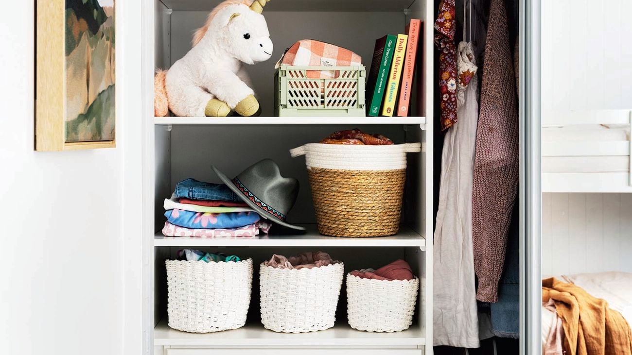 Wardrobe with a set of drawers in it and shelves with toys and baskets on them