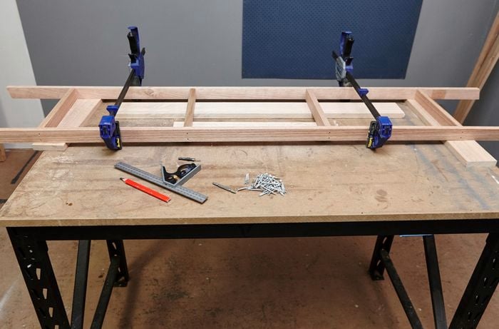 The tools and materials required for the job, including clamps, a square rule, a pencil, various lengths of timber and several bolts