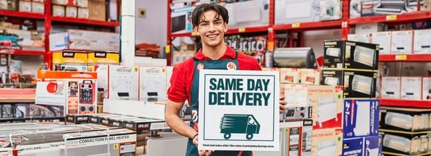 Bunnings team member holding same day delivery sign