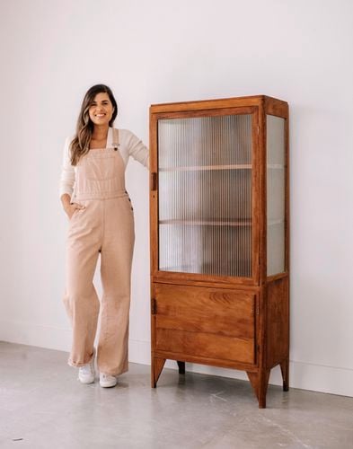 Timber and frosted glass tall display cabinet with lady standing next to it
