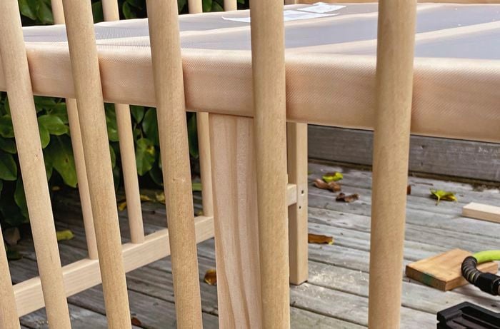 Close up shot of back support under cot behind wooden rails