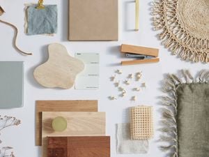 A flatlay of a moodboard featuring interior accessories and materials in pale green and neutral colours.