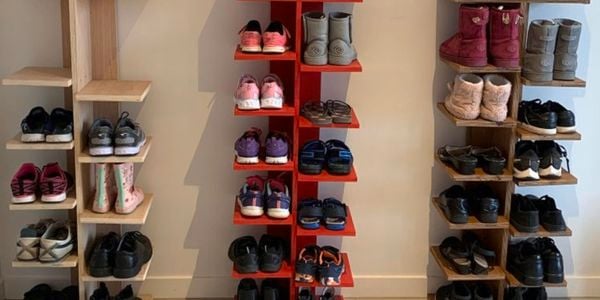 Three vertical shoe racks with shoes and toys