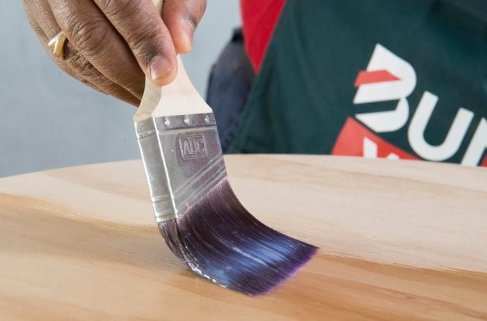 Person applying finish to tabletop
