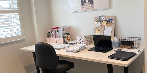 Timber top desk with desk chair, laptop and office supplies