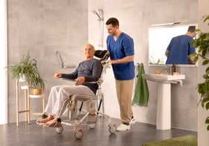 Man in wheelchair, he has a carer with him assisting in the bathroom