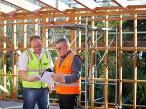 Two men reading house plans.