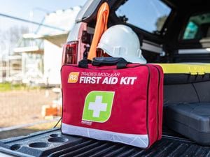 Fast aid kit next to a car ready to use if needed