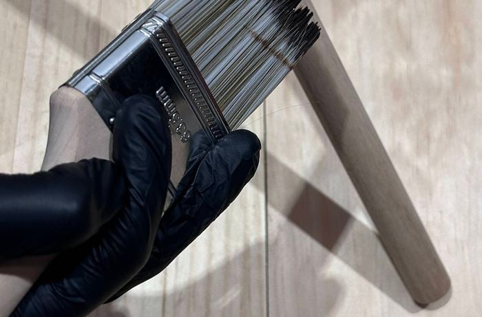 A paintbrush being used to stain dowel