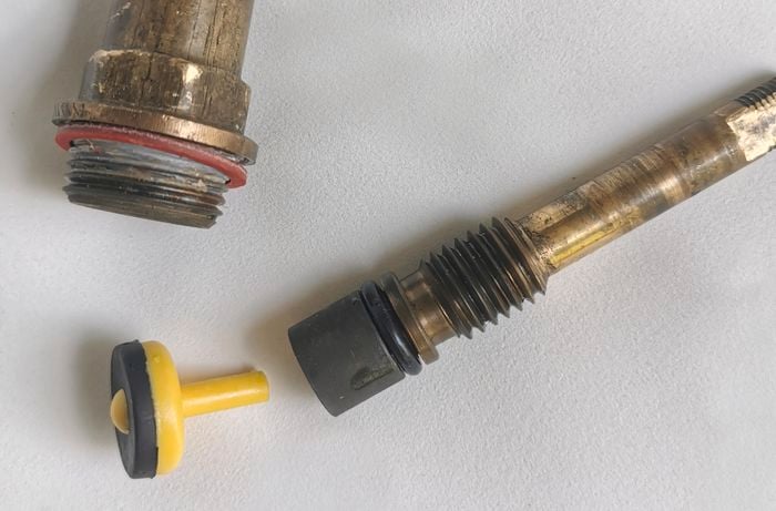 An o-ring, body washer and tap valve laid on a white background.