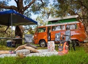 Orange combi, gazebo, camping chairs and table.