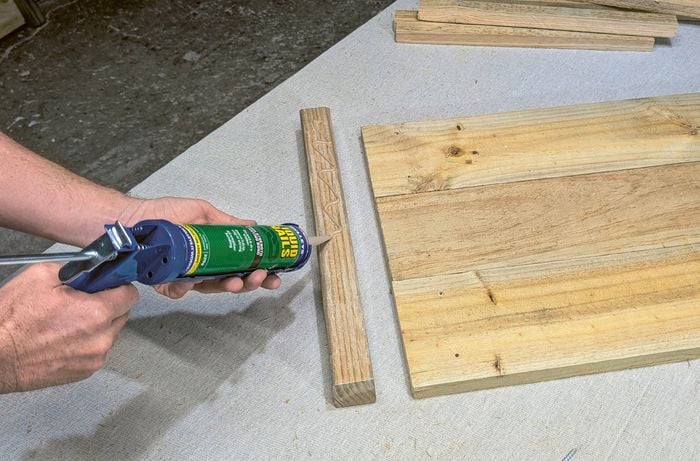 Hands applying adhesive to a piece of timber.