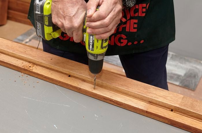 Person drilling into a thin bit of timber.
