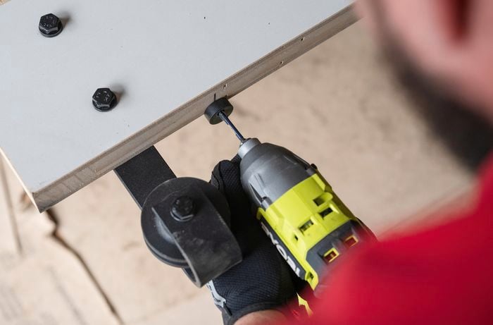 Team member attaching anti-jump blocks with a drill.