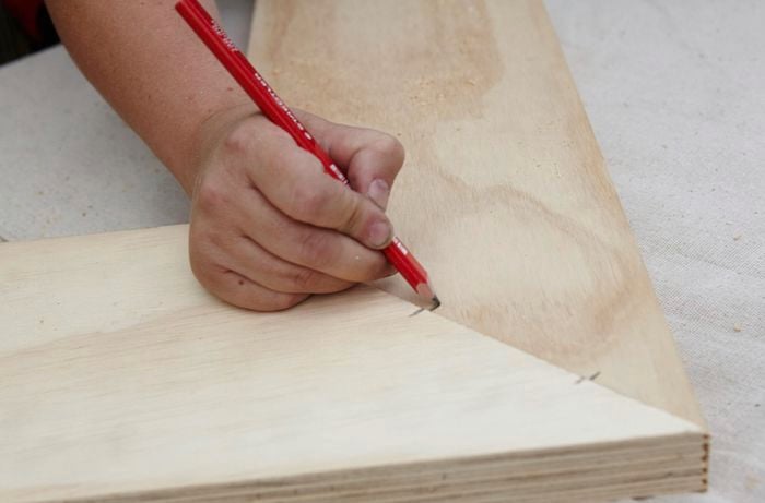 Two pieces of timber marked for the positioning of drilled holes for dowel