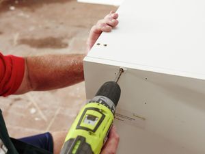 A Bunnings team member joining two parts of a pantry kit