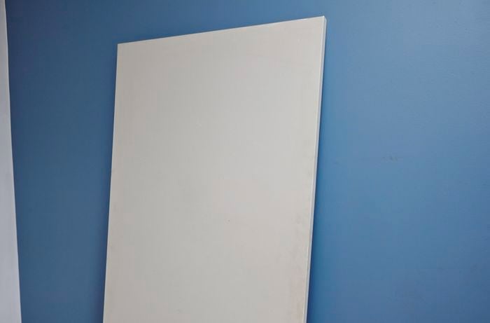 Freshly painted door sitting against the wall so it can dry.