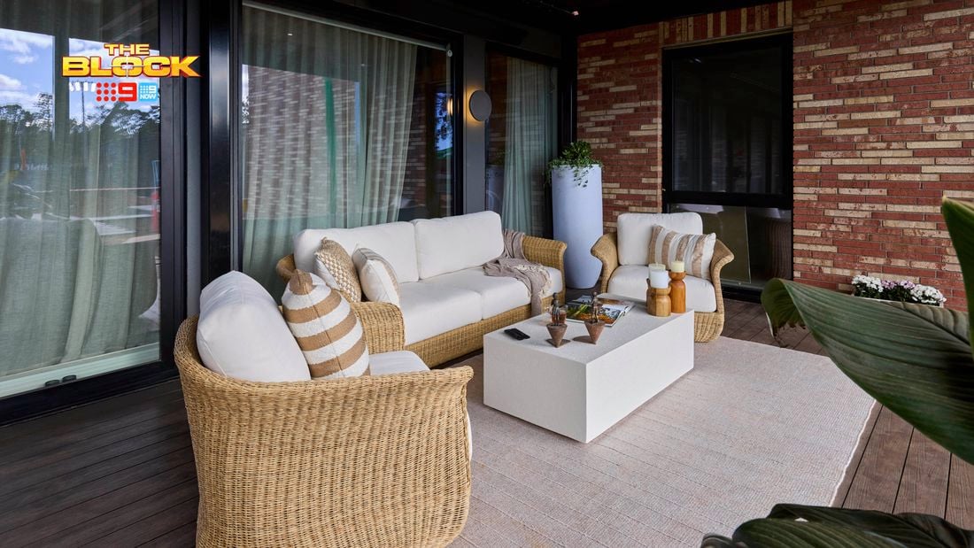 Outdoor area with a couch, chairs and table on a decking area.