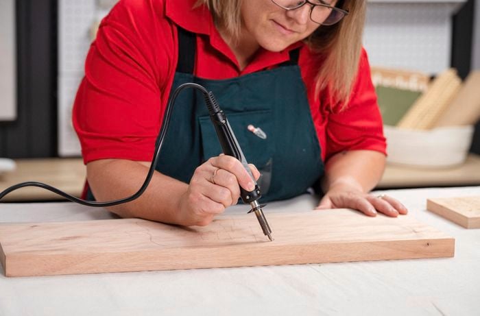 Engraving the Happy Mother's Day design using a soldering iron.