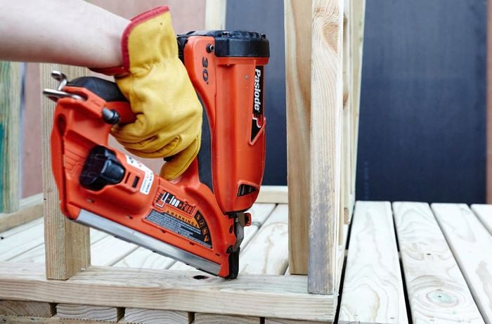 Person drilling timber frame pieces together.