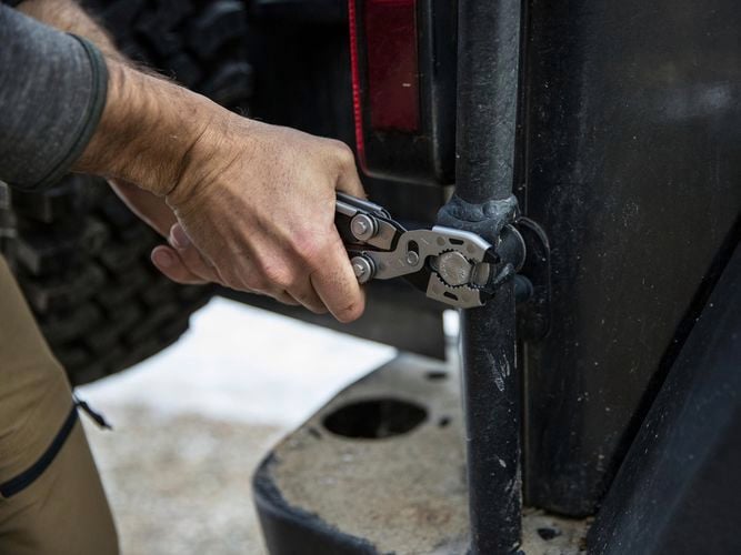 A person rotating a nut using dual force multi tool.