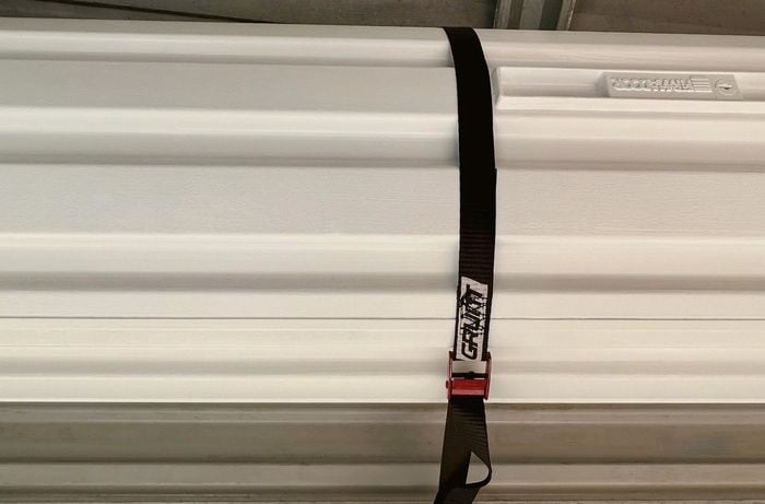 Roller drum is secured with tie-down strap.