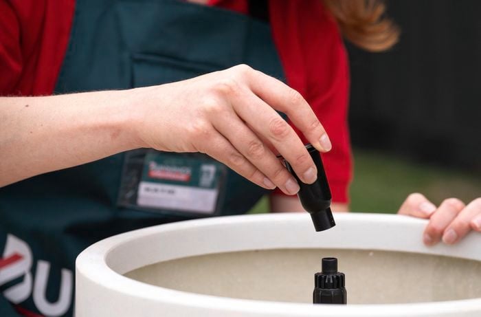 A Bunnings Team Member putting parts together for a water feature