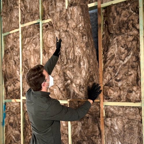 Man installing insulation wearing ppe.